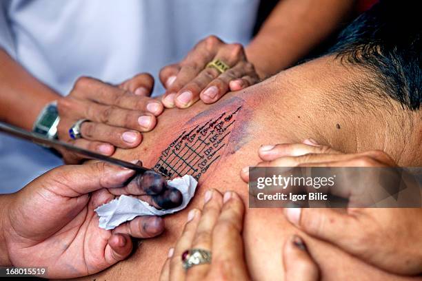 thai buddhist monks tatooing at the local temple - monk tattoos stock pictures, royalty-free photos & images