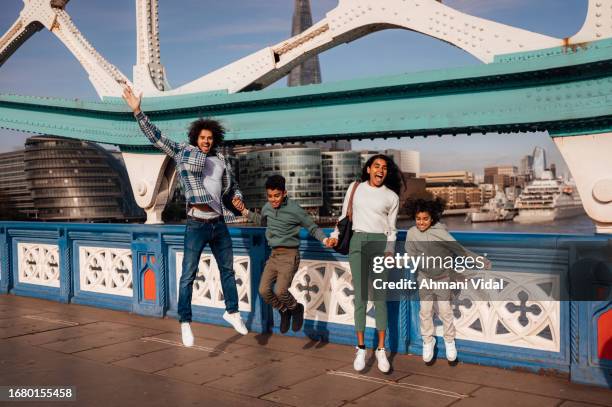 a family joyfully skip and jump together while holding hands. - skipping along stock pictures, royalty-free photos & images