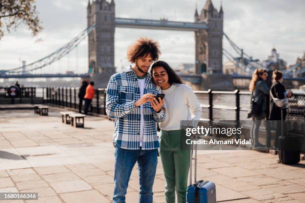 un matrimonio que usa su teléfono para navegar por la ciudad. - turista fotografías e imágenes de stock