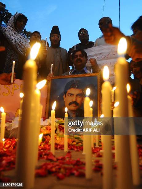 Activists of the ruling Pakistan Peoples party light candels in front of the picture of slain minority affairs minister Shahbaz Bhatti in Lahore on...