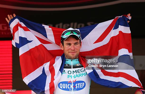 Mark Cavendish of Great Britain and Omega Pharma - Quick-Step poses with a Union Jack as he celebrates his stage victory on the podium after stage...
