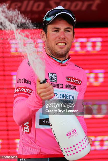 Mark Cavendish of Great Britain and Omega Pharma - Quick-Step celebrates claiming the Maglia Rosa on the podium following his victory in stage one...