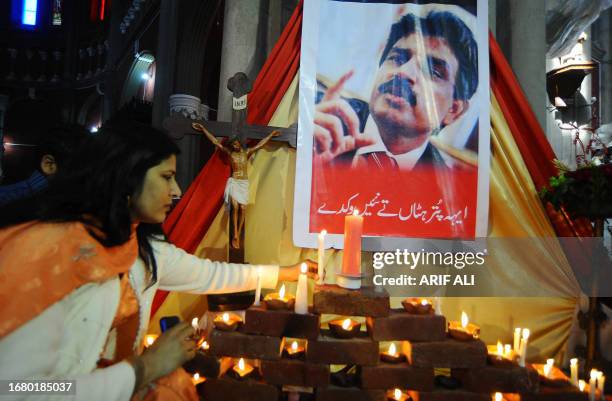 Pakistani Christian woman lights candles in front of a picture of slain Christian minister Shahbaz Bhatti at The Heart Cathedral Church in Lahore on...