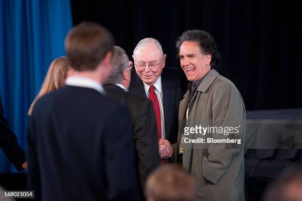 Charles Munger, vice chairman of Berkshire Hathaway Inc., center, shakes hands with Peter Buffett, son of Warren Buffett, chairman of Berkshire, at...