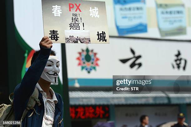 Protester wearing a Guy Fawkes mask, trademark of the anonymous movement and based on a character in the film V for Vendetta, holds a banner during a...