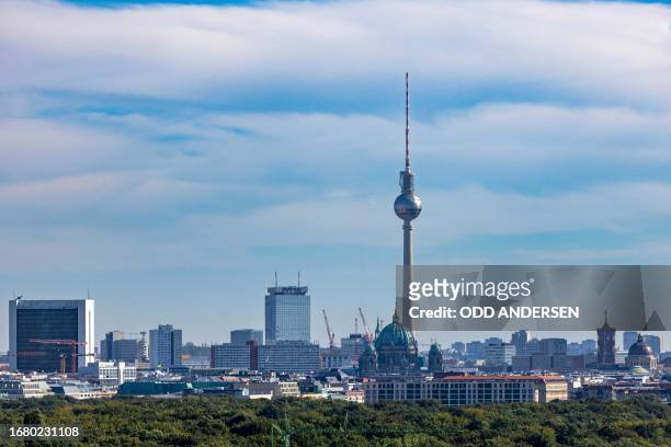 The landmark TV tower is seen on the skyline behind the canopy of trees in Tiergarten park in Berlin on September 21, 2023. The former gas storage...