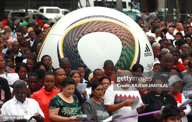 Christians from various denominations pray, near a giant 2010 World Cup official football "Jabulani" at the Good Friday mass after a street...
