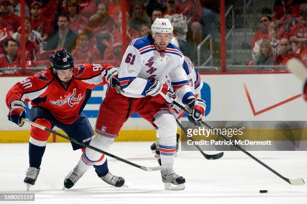 Rick Nash of the New York Rangers brings the puck up ice against Marcus Johansson of the Washington Capitals in the first period of Game Two of the...