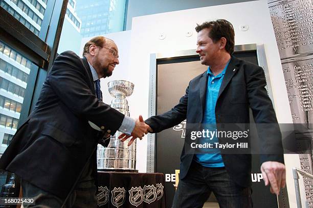 Actor James Lipton greets actor Michael J. Fox at the James Lipton and Stanley Cup in store event at NHL powered by Reebok Store on May 3, 2013 in...