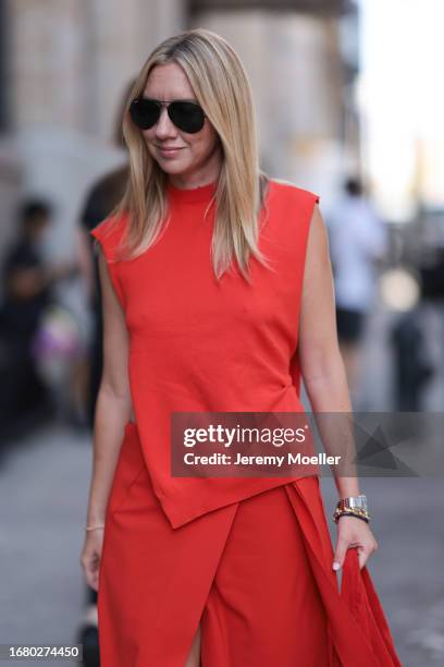 Lisa Aiken is seen outside Brandon Maxwell show wearing black aviator sunnies, red asymmetric top, matching red skirt with open front, red handbag...