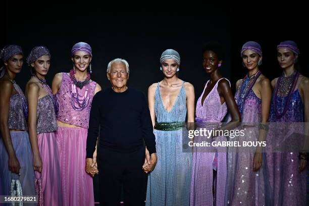 Italian designer Giorgio Armani poses with models on the runway at the end of the Emporio Armani fashion show during the Milan Fashion Week...