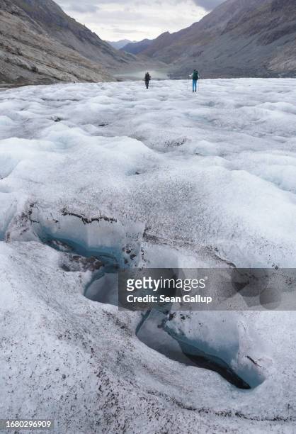 Scientists from the University of Graz walk across the tongue of the Pasterze glacier during annual data collection on September 13, 2023 near...