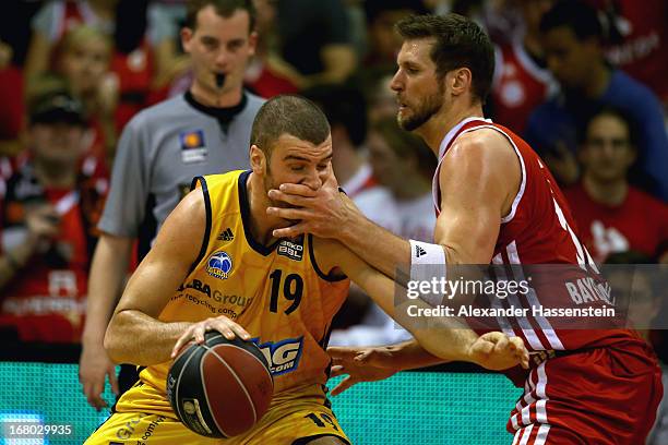 Jared Homan of Muenchen fights against Albert Miralles of Berlin during Game 1 of the quarterfinals of the Beko Basketball Playoffs between FC Bayern...