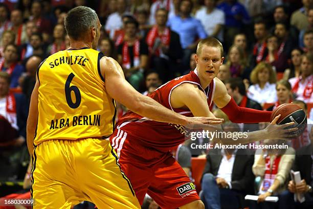 Robin Benzing of Muenchen shoots against Sven Schultze of Berlin during Game 1 of the quarterfinals of the Beko Basketball Playoffs between FC Bayern...