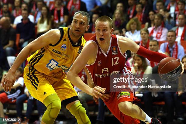Robin Benzing of Muenchen shoots against Sven Schultze of Berlin during Game 1 of the quarterfinals of the Beko Basketball Playoffs between FC Bayern...