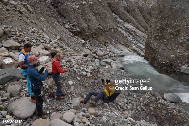 Andreas Kellerer-Pirklbauer-Eulenstein, a geographer at the University of Graz, prepares to pull himself across a cable over a river of meltwater to...