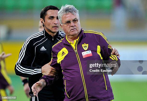 Head coach Guus Hiddink of FC Anzhi Makhachkala is held by an official during the Russian Premier League match between FC Anzhi Makhachkala and FC...