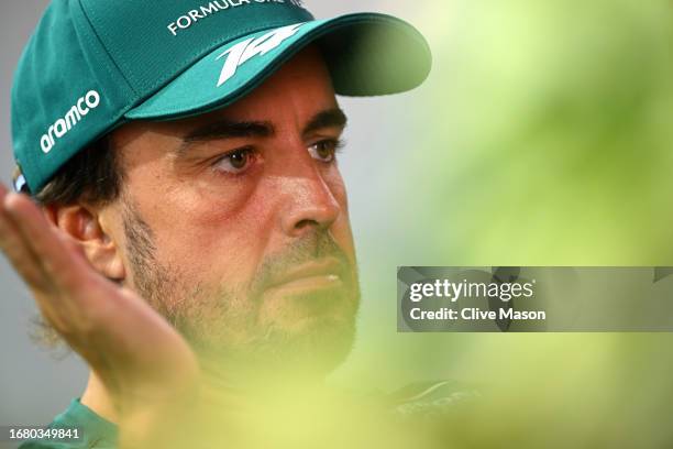 Fernando Alonso of Spain and Aston Martin F1 Team talks to the media in the Paddock during previews ahead of the F1 Grand Prix of Singapore at Marina...