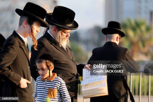 Ultra-Orthodox Jewish men and children gather in the coastal city of Netanya on September 21, 2023 to perform the "Tashlich" ritual during which...