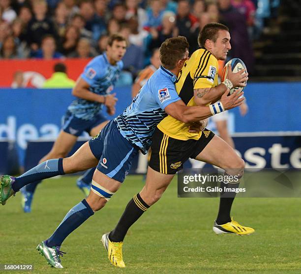 Wynand Olivier of the Bulls tackles Andre Taylor of the Hurricanes during the Super Rugby match between Vodacom Bulls and Hurricanes at Loftus...