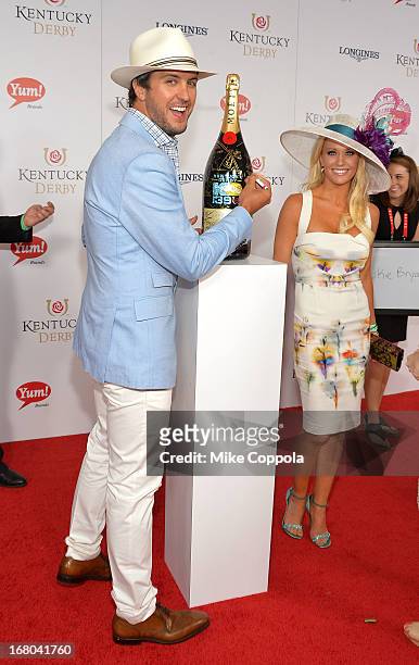 Singer Luke Bryan and wife Caroline Boyer sign the Moet & Chandon 6L for the Churchill Downs Foundation during the 139th Kentucky Derby at Churchill...