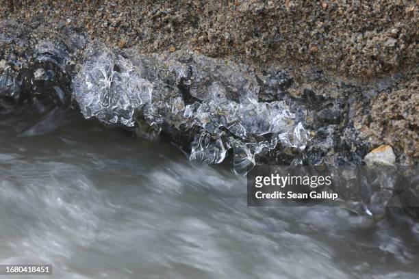 Meltwater flows below gravel-covered ice on the Pasterze glacier on September 12, 2023 near Heiligenblut, Austria. The Pasterze is losing length and...