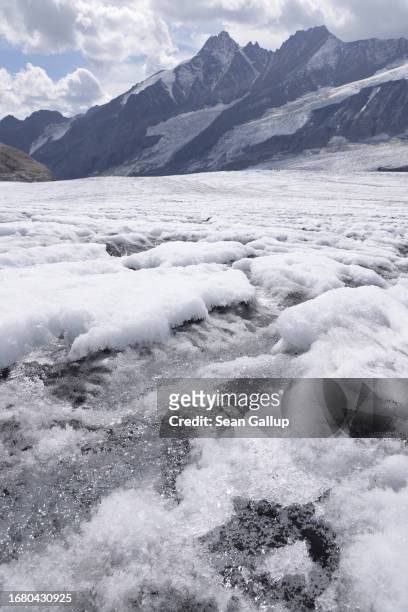 Meltwater flows across ice next to recent snow on the plateau of the Pasterze glacier on September 12, 2023 near Heiligenblut, Austria. The Pasterze...