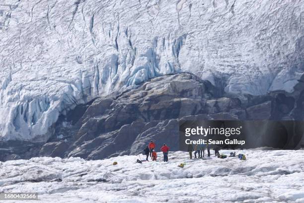 Mountaineers walk across the ice surface of the plateau of the Pasterze glacier on September 12, 2023 near Heiligenblut, Austria. The Pasterze is...
