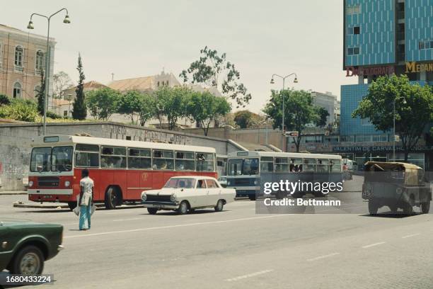 Two Yugoslav buses being driven on a street in Luanda, Angola, November 24th 1976. The buses were provided by the Republic of Yugoslavia to help...