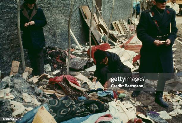 Man inspects his belongings amid debris on a street in Bucharest following a powerful earthquake in the Balkan region, Romania, March 7th 1977.