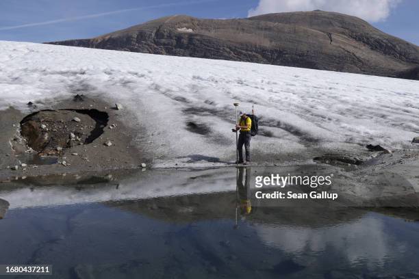 Andreas Kellerer-Pirklbauer-Eulenstein, a geographer at the University of Graz, is reflected in a pool of meltwater as he records a GPS reading at...