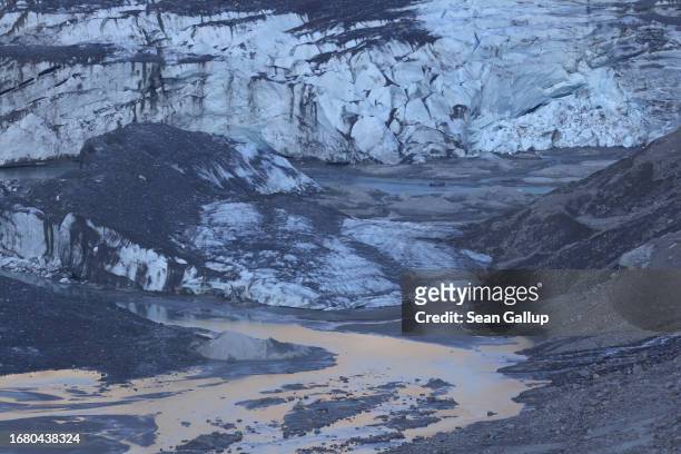 Lake of meltwater lies below the collapsing and gravel-covered terminus of the Pasterze glacier on September 12, 2023 near Heiligenblut, Austria. The...