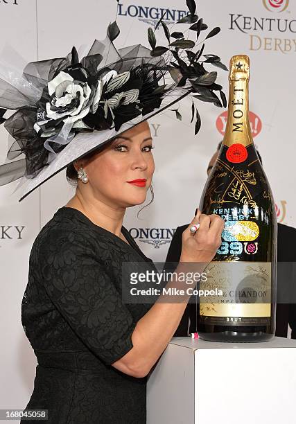 Actress Jennifer Tilley signs the Moet & Chandon 6L for the Churchill Downs Foundation during the 139th Kentucky Derby at Churchill Downs on May 4,...