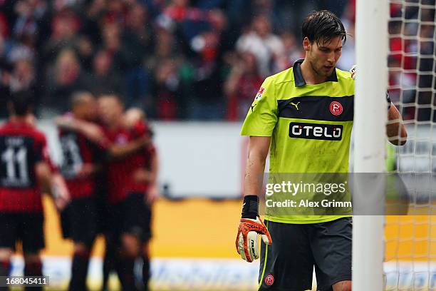 Goalkeeper Fabian Giefer of Duesseldorf reacts after Alexander Meier of Frankfurt and team mates celebrate in the background during the Bundesliga...