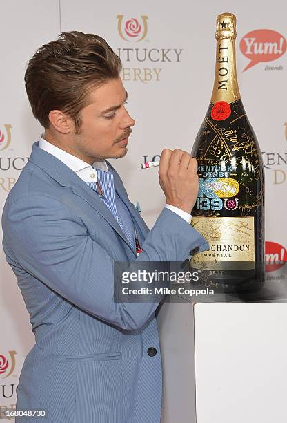 Actor Josh Henderson signs the Moet & Chandon 6L for the Churchill Downs Foundation during the 139th Kentucky Derby at Churchill Downs on May 4, 2013...
