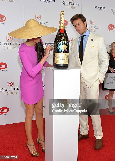 Actors Elizabeth Chambers and Armie Hammer sign the Moet & Chandon 6L for the Churchill Downs Foundation during the 139th Kentucky Derby at Churchill...