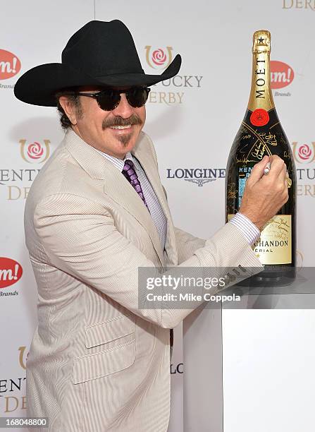 Kix Brooks signs the Moet & Chandon 6L for the Churchill Downs Foundation during the 139th Kentucky Derby at Churchill Downs on May 4, 2013 in...