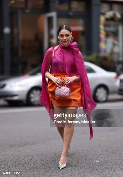 Oralia A. Villarreal Cantú was seen wearing a light pink Miu Miu bag, a black bra, a orange silk skirt, silver high heels and a transparent pink top...