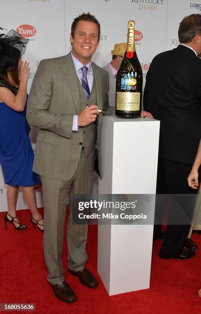 Personality Bob Guiney signs the Moet & Chandon 6L for the Churchill Downs Foundation during the 139th Kentucky Derby at Churchill Downs on May 4,...