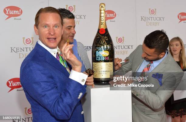 Carson Kressley signs the Moet & Chandon 6L for the Churchill Downs Foundation during the 139th Kentucky Derby at Churchill Downs on May 4, 2013 in...