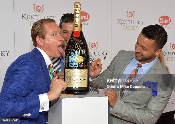 Carson Kressley and Jai Rodriguez sign the Moet & Chandon 6L for the Churchill Downs Foundation during the 139th Kentucky Derby at Churchill Downs on...