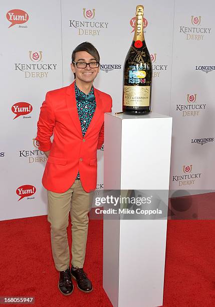 Designer Christian Siriano signs the Moet & Chandon 6L for the Churchill Downs Foundation during the 139th Kentucky Derby at Churchill Downs on May...