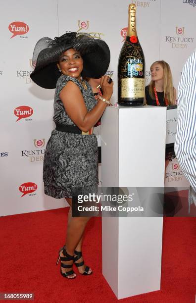 Actress Brely Evans signs the Moet & Chandon 6L for the Churchill Downs Foundation during the 139th Kentucky Derby at Churchill Downs on May 4, 2013...