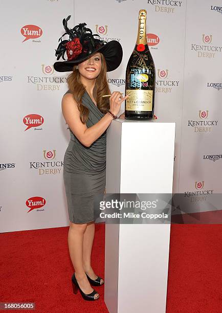 Angie Johnson signs the Moet & Chandon 6L for the Churchill Downs Foundation during the 139th Kentucky Derby at Churchill Downs on May 4, 2013 in...
