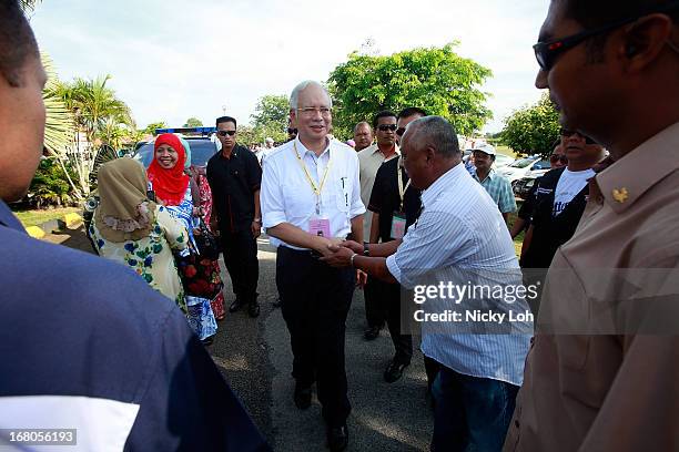 Malaysia's Prime Minister and Barisan Nasional chairman Najib Razak greets voters at a polling station during election day on May 5, 2013 in Pekan,...