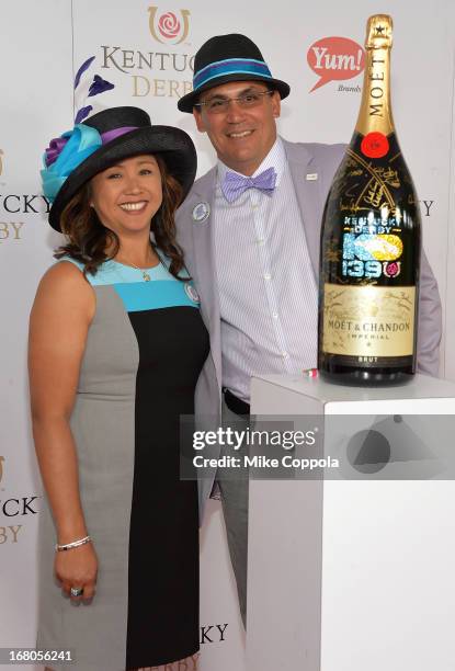 Coach Ron Rivera and Stephanie Rivera sign the Moet & Chandon 6L for the Churchill Downs Foundation during the 139th Kentucky Derby at Churchill...