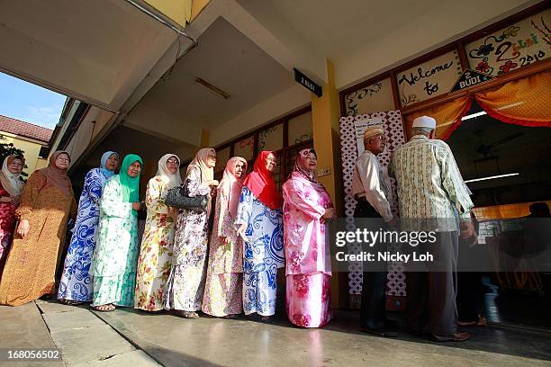 Voters line up at a polling station during election day on May 5, 2013 in Pekan, Malaysia. Millions of Malaysians casted their vote on Sunday in one...