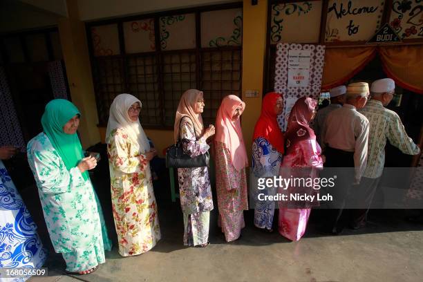 Voters line up at a polling station during election day on May 5, 2013 in Pekan, Malaysia. Millions of Malaysians casted their vote on Sunday in one...