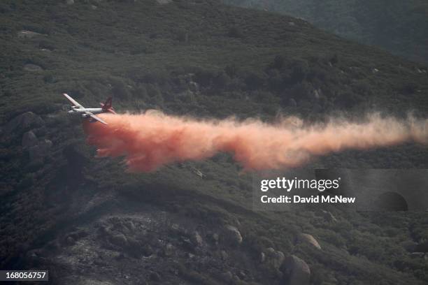 Firefighting air tanker plane drops fire retardant in Hidden Valley at the Springs fire on May 4, 2013 near Camarillo, California. Improving weather...