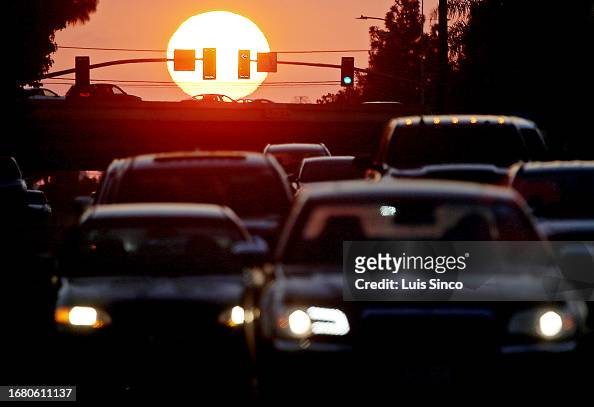 Motor traffic stacks up at the intersection of Wardlow Road and the 405 Freeway in Long Beach as the sun sets behind a reddish veil of smog on Wednesday, Sept. 20, 2023, just days ahead of the autumn equinox, which marks the last day of summer.